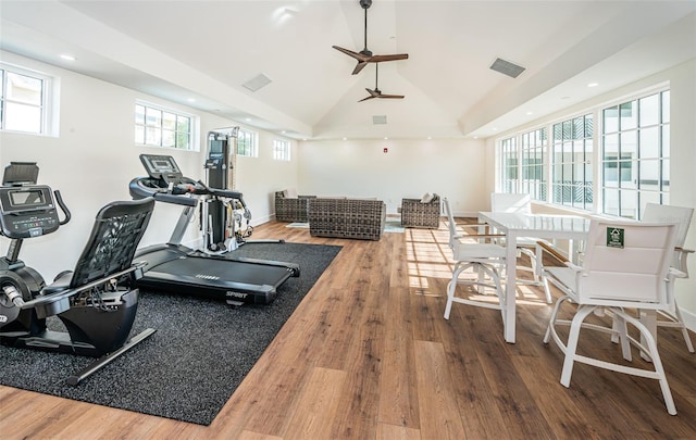 exercise room featuring ceiling fan, high vaulted ceiling, and wood-type flooring