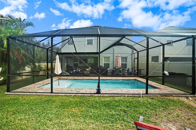 view of swimming pool with glass enclosure, a patio area, and a yard