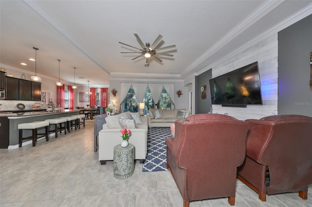 living room with ceiling fan, sink, and ornamental molding