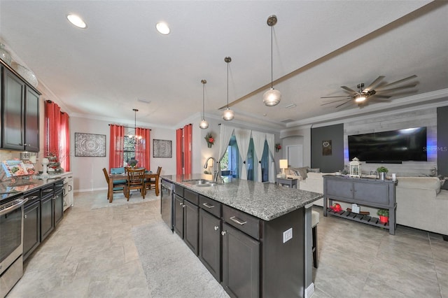 kitchen with pendant lighting, a kitchen island with sink, ornamental molding, and sink