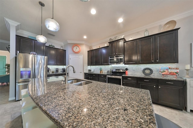 kitchen with crown molding, sink, appliances with stainless steel finishes, and an island with sink