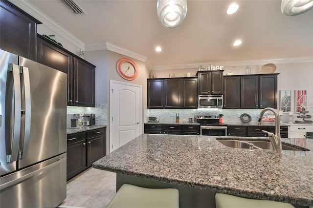 kitchen with sink, decorative backsplash, ornamental molding, a kitchen bar, and stainless steel appliances