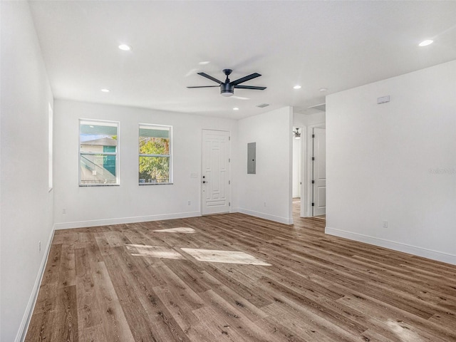 unfurnished room with electric panel, ceiling fan, and hardwood / wood-style flooring