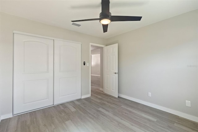 unfurnished bedroom with light hardwood / wood-style floors, a closet, and ceiling fan