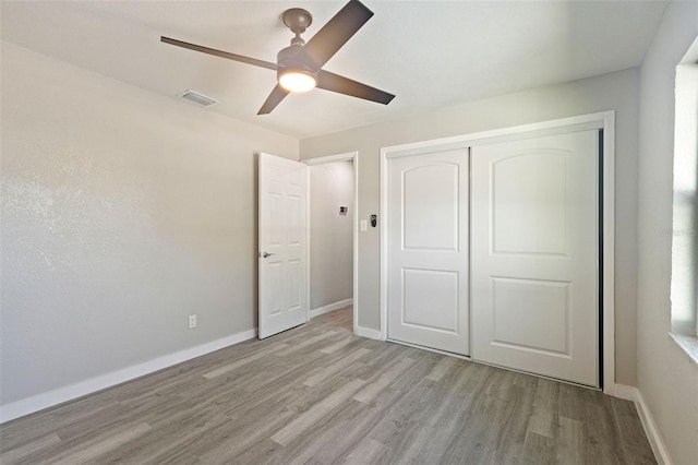 unfurnished bedroom with light hardwood / wood-style floors, a closet, and ceiling fan