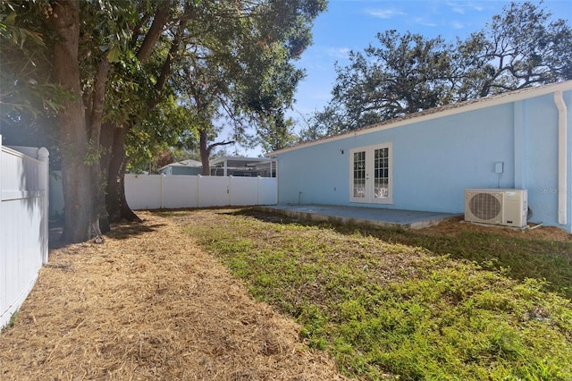 view of yard featuring a patio, ac unit, and french doors