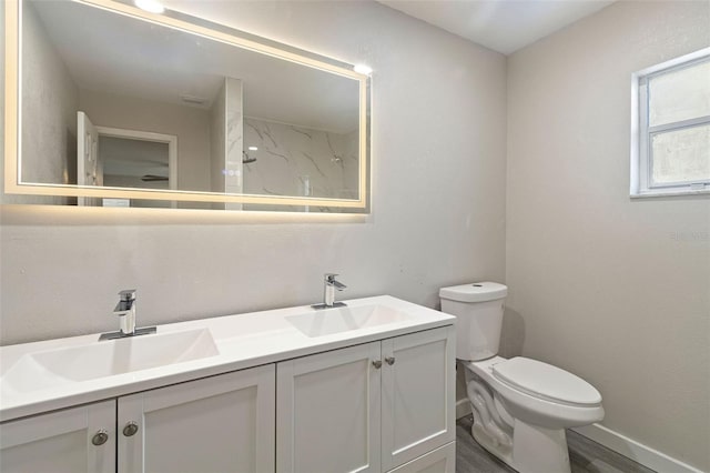 bathroom with a sink, a shower, toilet, and double vanity