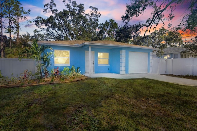 ranch-style house with a garage, concrete driveway, a yard, and fence