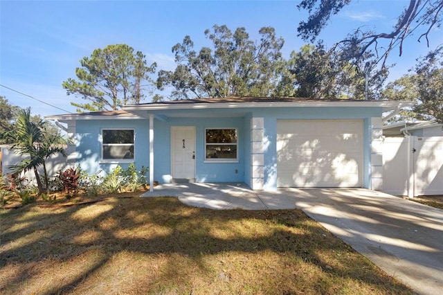 ranch-style house with stucco siding, concrete driveway, a garage, and a front yard