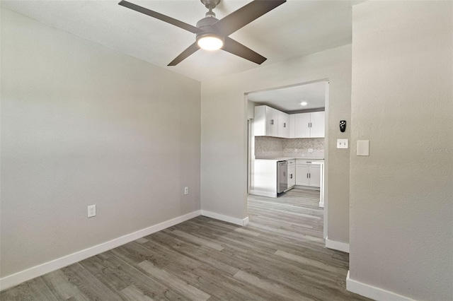 unfurnished room with baseboards, light wood finished floors, and ceiling fan