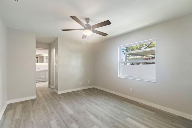 unfurnished room featuring a ceiling fan, wood finished floors, and baseboards