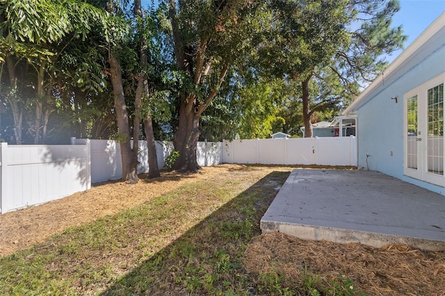 view of yard with a patio, french doors, and a fenced backyard