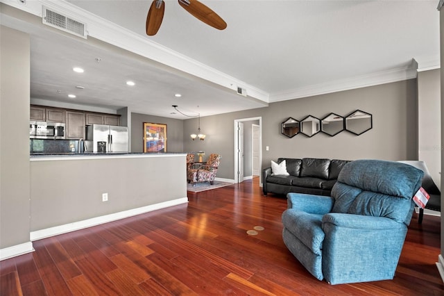 living room featuring ceiling fan with notable chandelier, dark hardwood / wood-style flooring, and ornamental molding