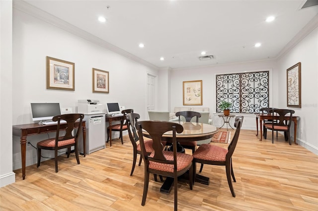 dining space with light hardwood / wood-style floors and crown molding