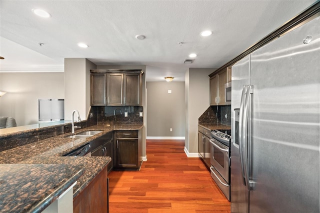 kitchen with backsplash, sink, dark wood-type flooring, and appliances with stainless steel finishes