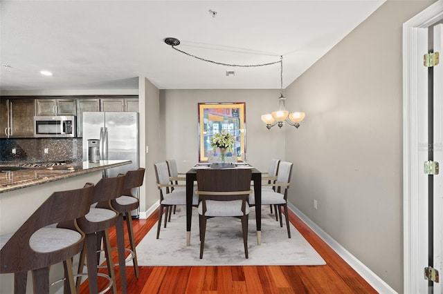 dining area featuring dark hardwood / wood-style floors and a notable chandelier