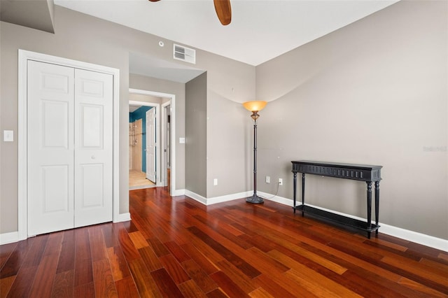 unfurnished bedroom featuring ceiling fan, dark hardwood / wood-style floors, and a closet