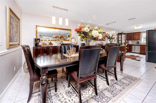 dining room featuring light tile patterned floors and ornamental molding