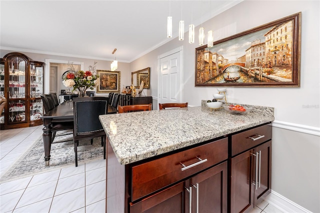 kitchen featuring light stone counters, ornamental molding, hanging light fixtures, and light tile patterned floors