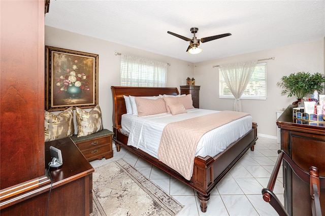 bedroom with ceiling fan, light tile patterned floors, and a textured ceiling