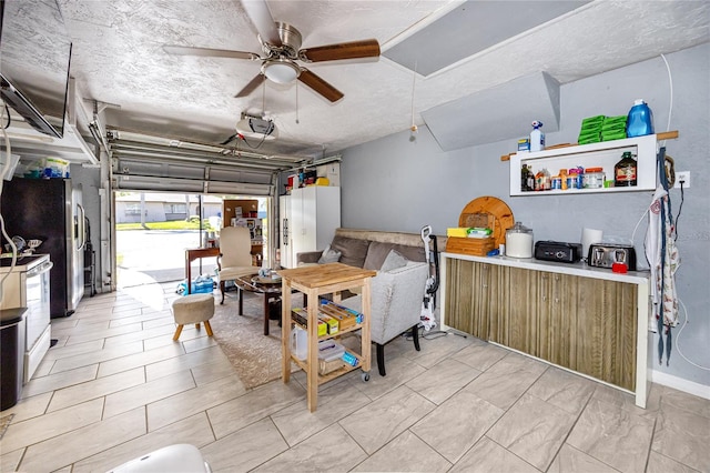 garage with a garage door opener, ceiling fan, and stainless steel refrigerator