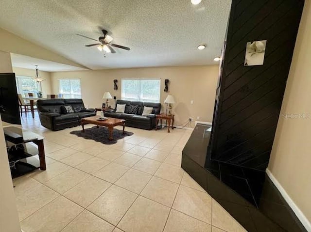 tiled living room with ceiling fan and a textured ceiling