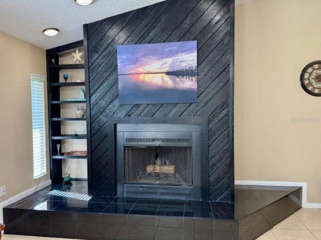 details featuring built in features, tile patterned flooring, wood walls, a textured ceiling, and a tiled fireplace