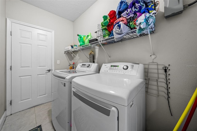 laundry room with independent washer and dryer, a textured ceiling, and light tile patterned floors