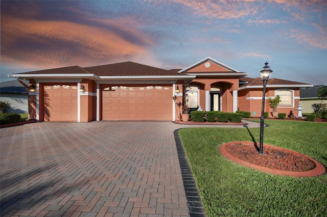 view of front facade with a yard and a garage