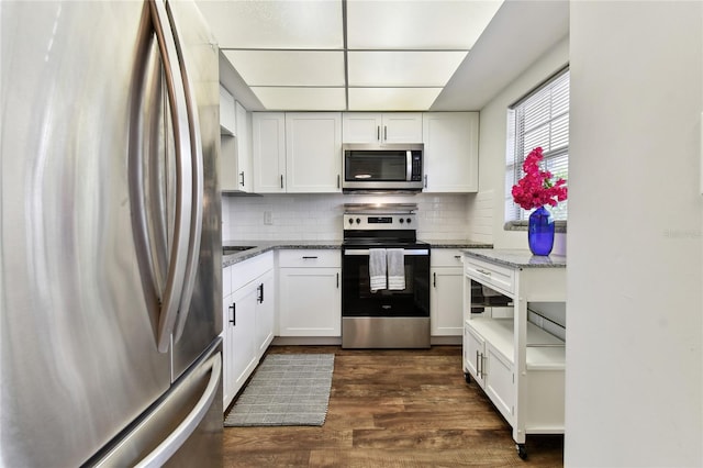 kitchen featuring stone counters, appliances with stainless steel finishes, dark hardwood / wood-style flooring, and white cabinetry