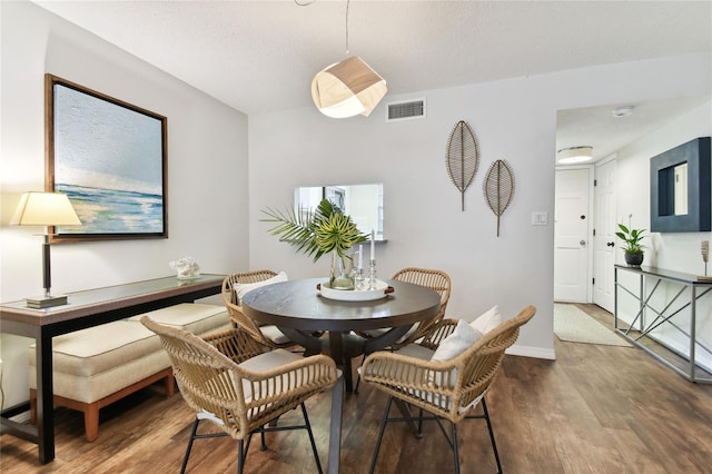 dining area featuring a textured ceiling and dark hardwood / wood-style floors