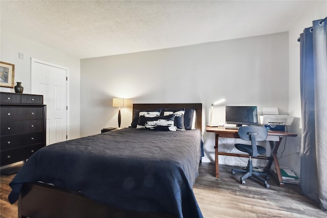 bedroom featuring hardwood / wood-style floors and a textured ceiling