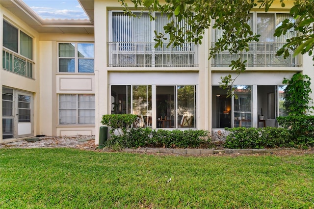 rear view of property featuring a lawn