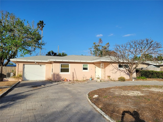 ranch-style house with a garage and central air condition unit