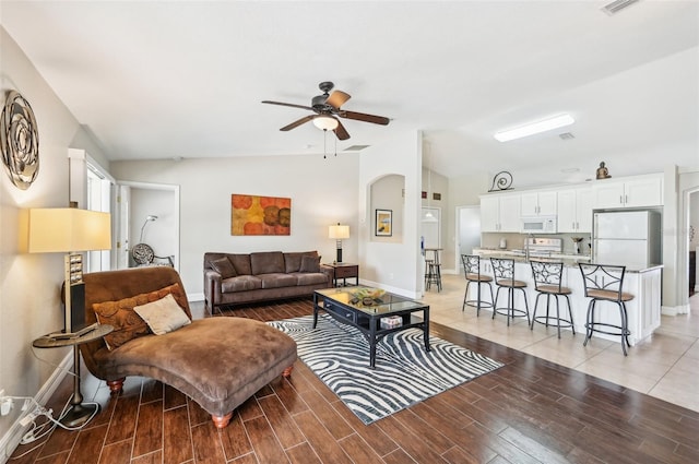 living room with light hardwood / wood-style floors, ceiling fan, and lofted ceiling