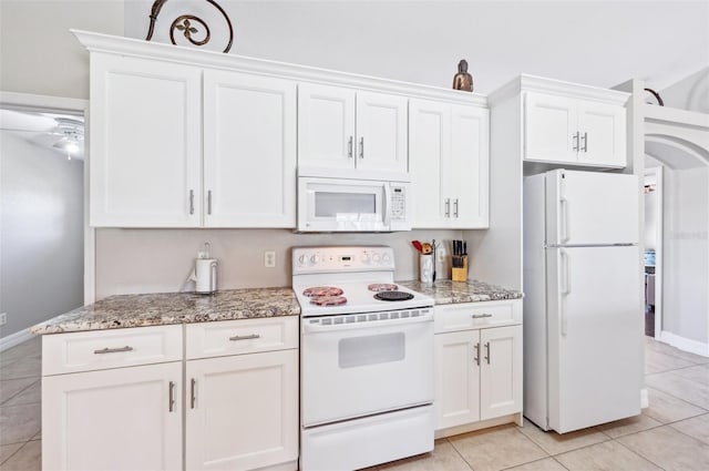 kitchen featuring white cabinetry, light stone counters, white appliances, and light tile patterned flooring