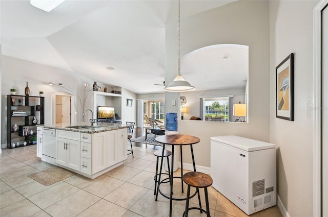 kitchen featuring white cabinetry, dishwasher, sink, light stone counters, and refrigerator