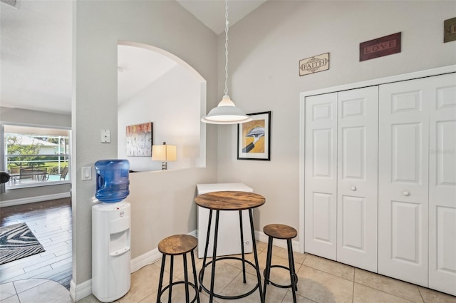 interior space featuring light tile patterned flooring and lofted ceiling