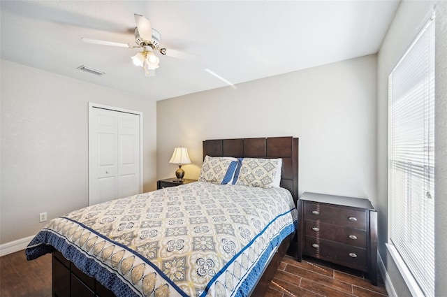 bedroom with ceiling fan, dark hardwood / wood-style flooring, and a closet