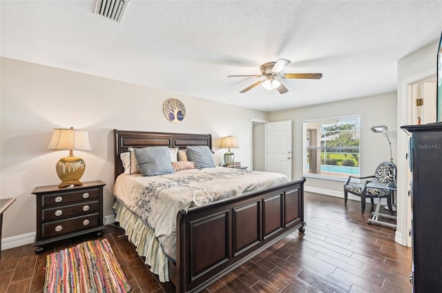 bedroom featuring a textured ceiling, ceiling fan, and dark wood-type flooring