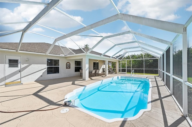 view of swimming pool with a patio, glass enclosure, and ceiling fan