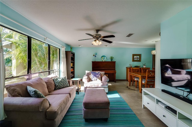 living room with ceiling fan and a textured ceiling