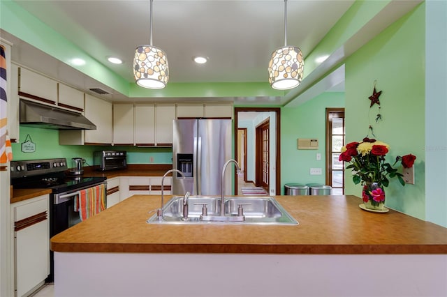 kitchen with a kitchen island with sink, sink, hanging light fixtures, and appliances with stainless steel finishes