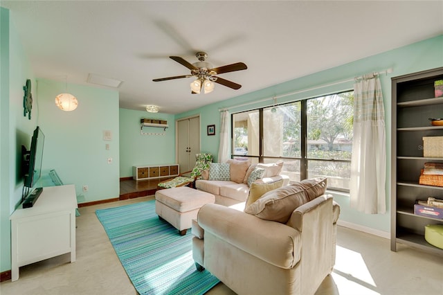 living area featuring ceiling fan and baseboards