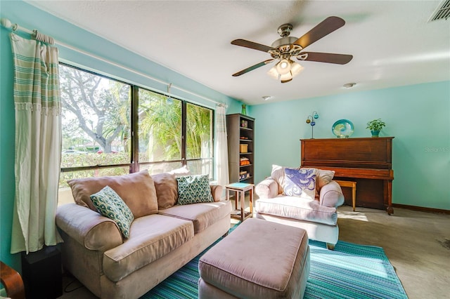 living room featuring a ceiling fan, visible vents, and baseboards