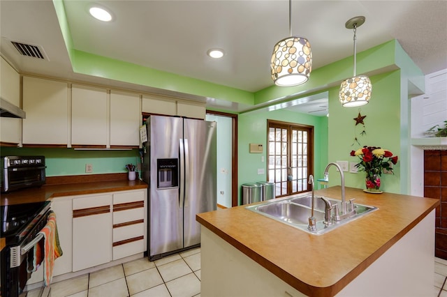 kitchen featuring light tile patterned floors, a sink, visible vents, appliances with stainless steel finishes, and decorative light fixtures