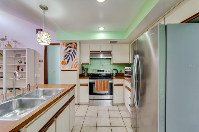 kitchen with light tile patterned floors, hanging light fixtures, stainless steel appliances, ventilation hood, and a sink