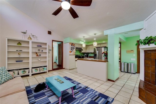 living room featuring light tile patterned floors, a ceiling fan, vaulted ceiling, a textured ceiling, and baseboards