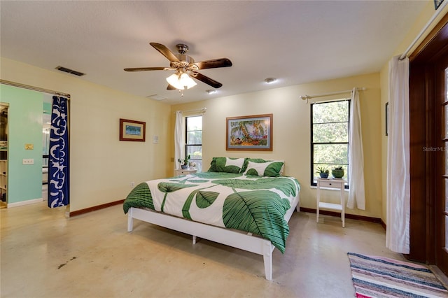 bedroom with visible vents, concrete floors, a ceiling fan, and baseboards