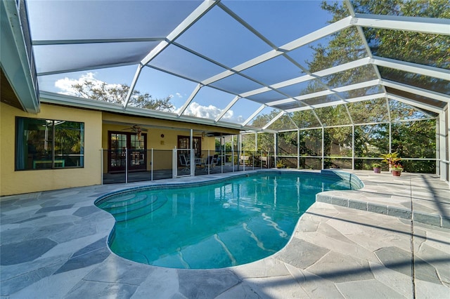 pool featuring a lanai, a patio area, and a ceiling fan